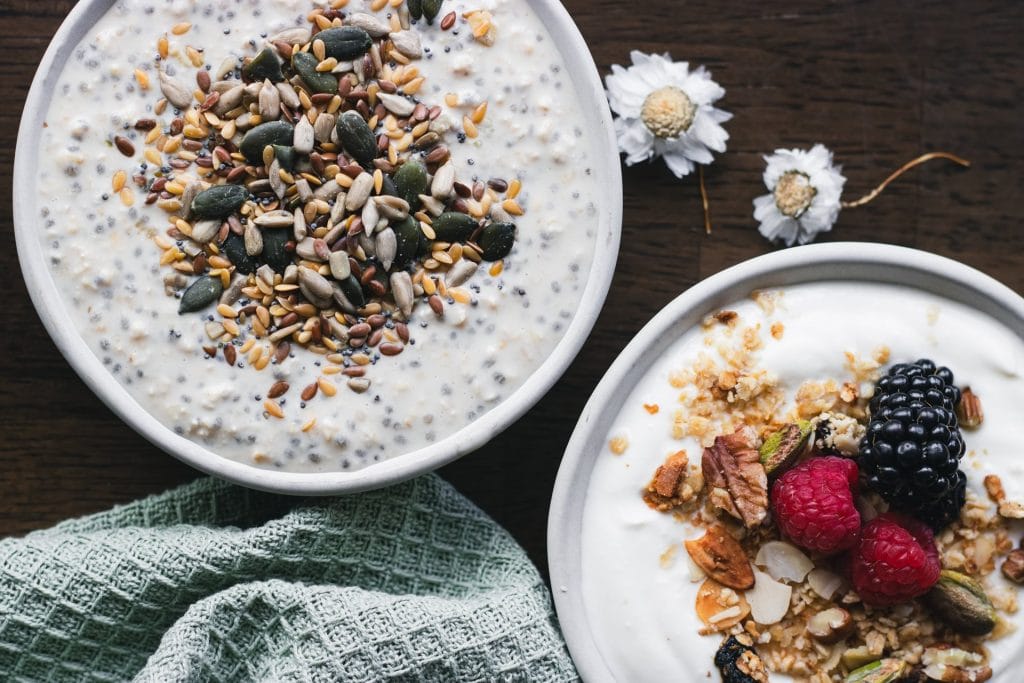 Granola and yoghurt breakfast bowls topped with berries, nuts and seeds