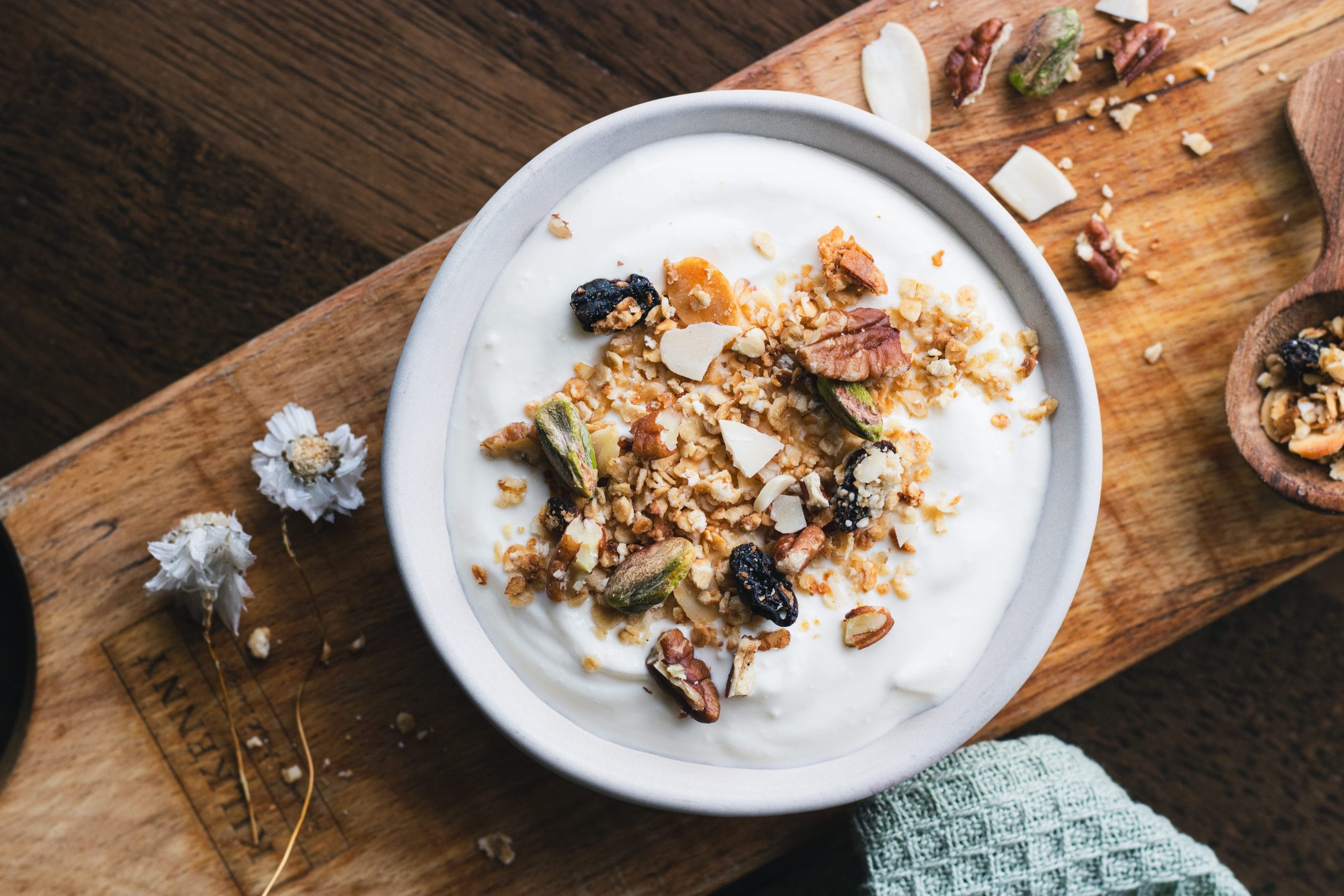 Granola and yoghurt bowl topped with fruit, nuts and seeds